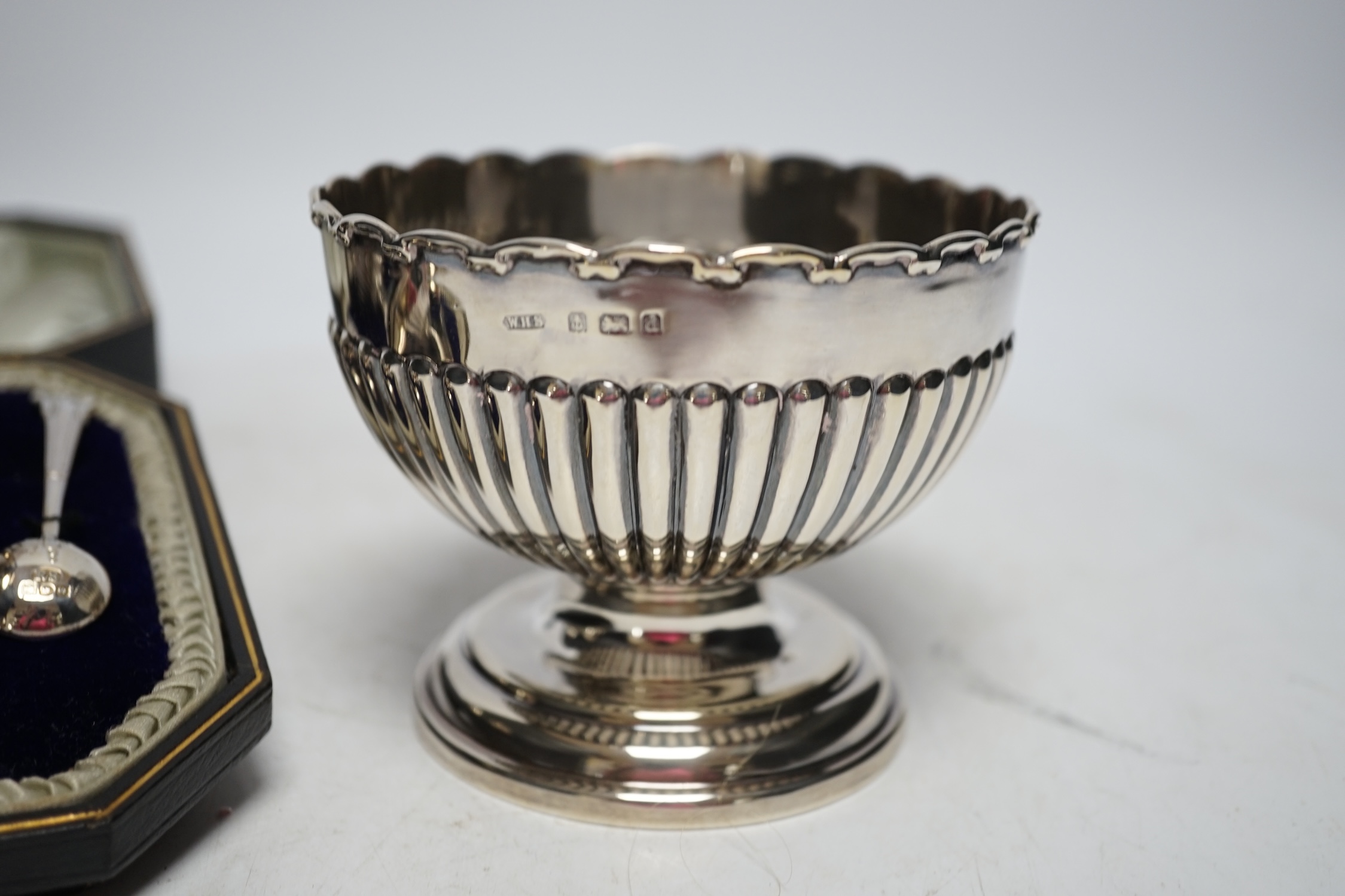 An Edwardian small silver pedestal bowl, Birmingham, 1903, diameter 10.5cm and a cased pair of George V silver salts and spoons. Fair condition.